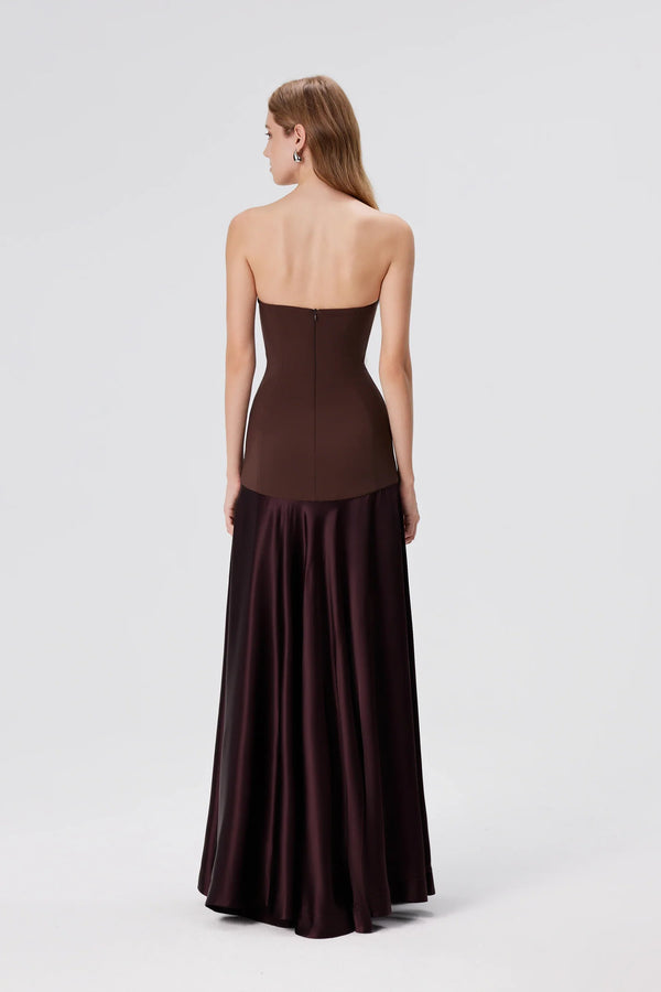 Woman wearing a strapless brown evening gown on a white background