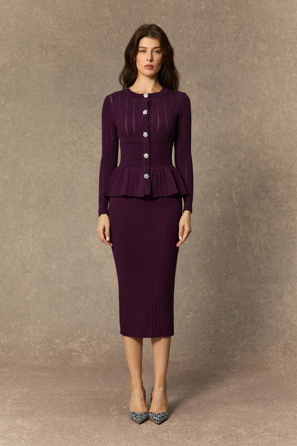 Woman wearing a purple peplum top and skirt against a brown background