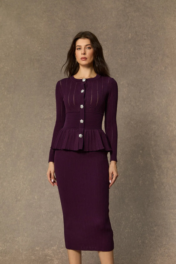 Woman wearing a purple peplum top and skirt set against a brown background