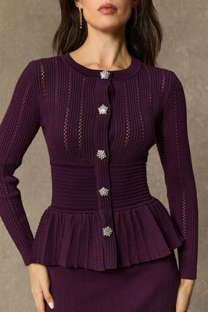Purple ribbed knit cardigan with decorative buttons on a neutral background