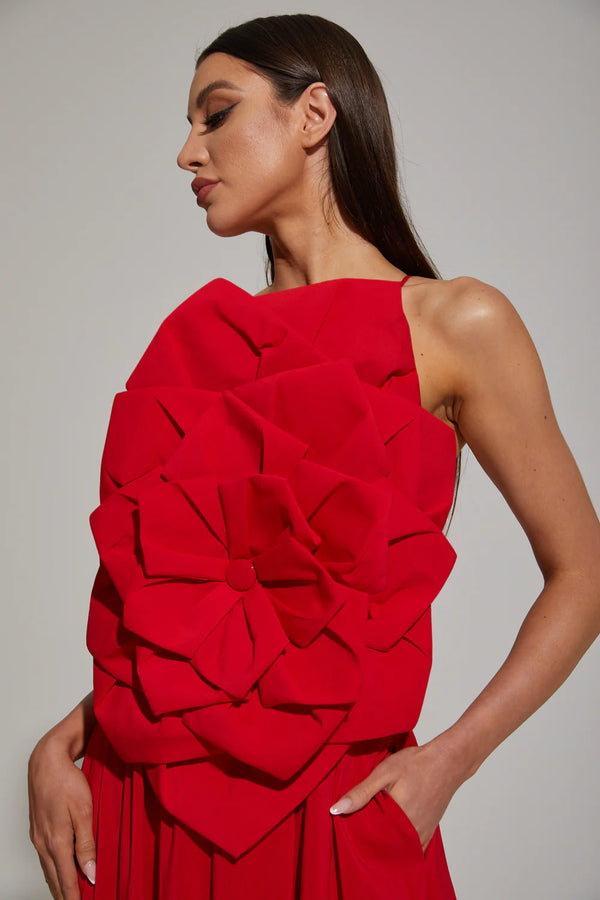 Woman wearing a red dress with ruffled details against a gray background