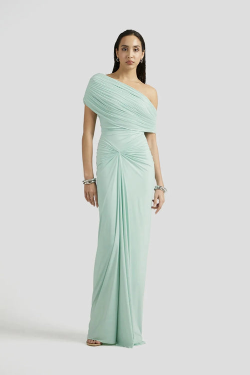 Woman wearing a light green one-shoulder dress on a white background