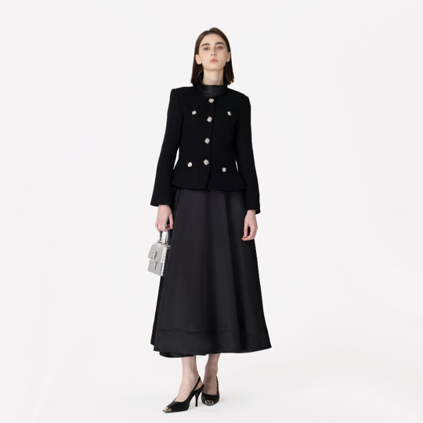 Woman wearing a black coat and skirt set on a white background