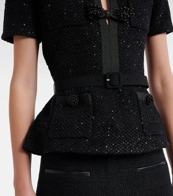 Black textured dress with a bow detail on a white background