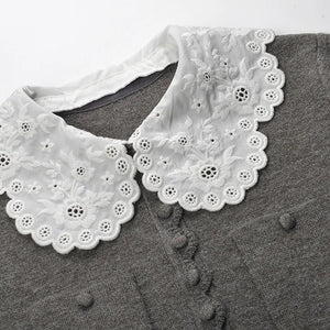 White lace collar on a gray shirt with a white background