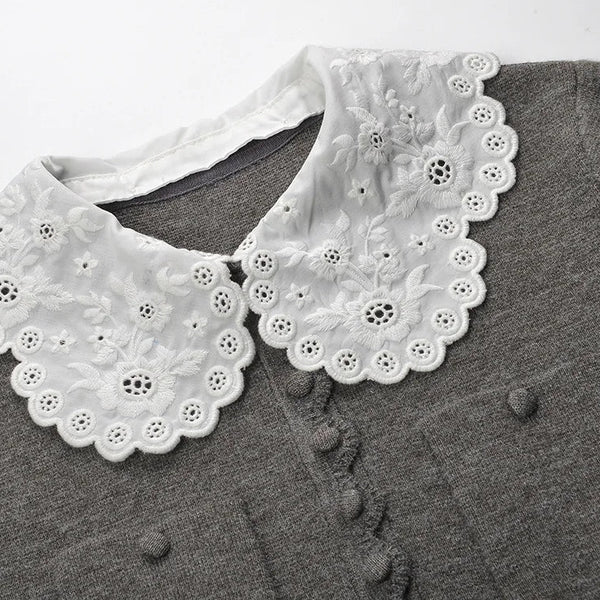 White lace collar on a gray shirt with a white background