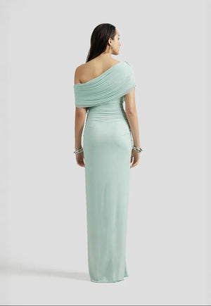 Woman wearing a light green one-shoulder dress on a white background