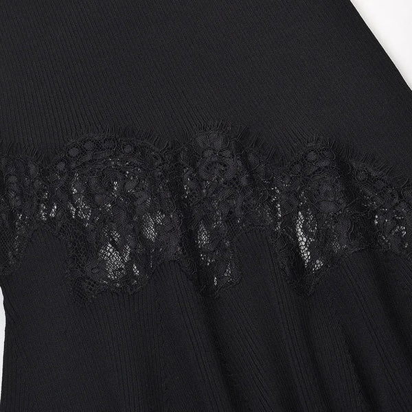 Close-up of a black ribbed knit garment with a wide black lace band across the waist or hip area, shown against a plain light background.