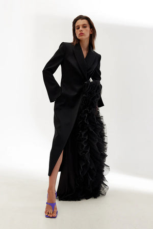 Woman wearing a black ruffled dress with a white background