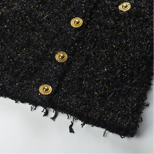 Black textured fabric with gold buttons on a white background
