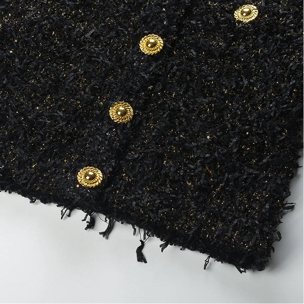 Black textured fabric with gold buttons on a white background