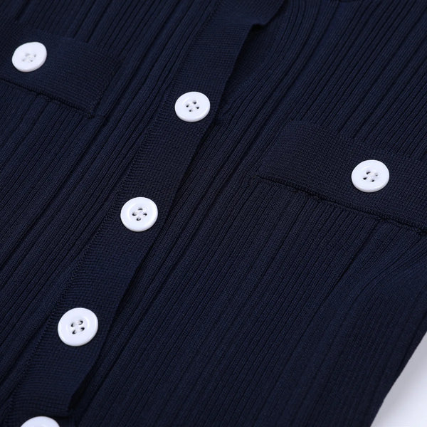 Close-up of a navy blue ribbed sweater with white buttons