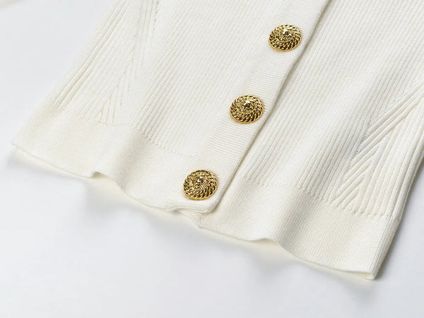 Close-up of a white textured fabric with gold buttons on a light gray background