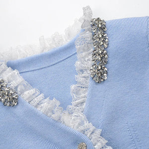 Light blue garment with white lace and decorative silver elements on a white background