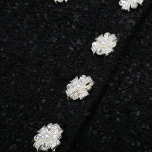 Pearl and crystal flower-shaped jewelry on a black fabric background