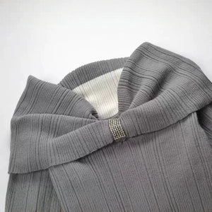 Gray ribbed sweater with a decorative button on a white background