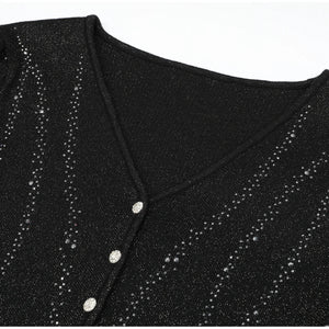 Black glittery top with button details on a white background