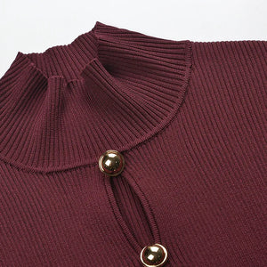 Close-up of a maroon ribbed sweater with gold buttons on a light gray background