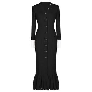 Black dress with buttons and a ruffled hem on a white background