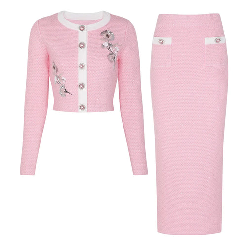 Pink textured dress with floral embellishments on a white background