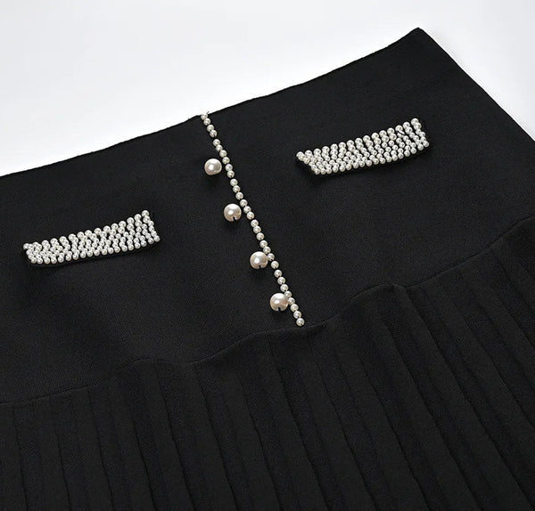 Black pleated skirt with pearl embellishments on a white background