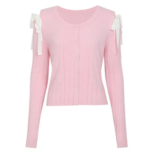 Pink long-sleeve top with white bow details on a white background