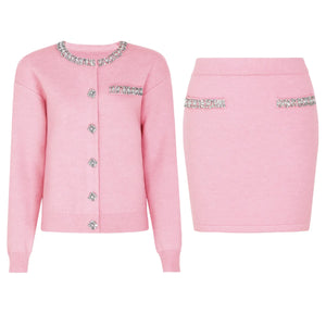 Pink cardigan and skirt set with embellishments on a white background