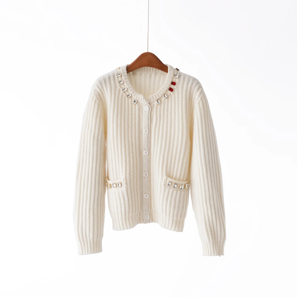 White ribbed knit cardigan with decorative buttons on a wooden hanger against a white background