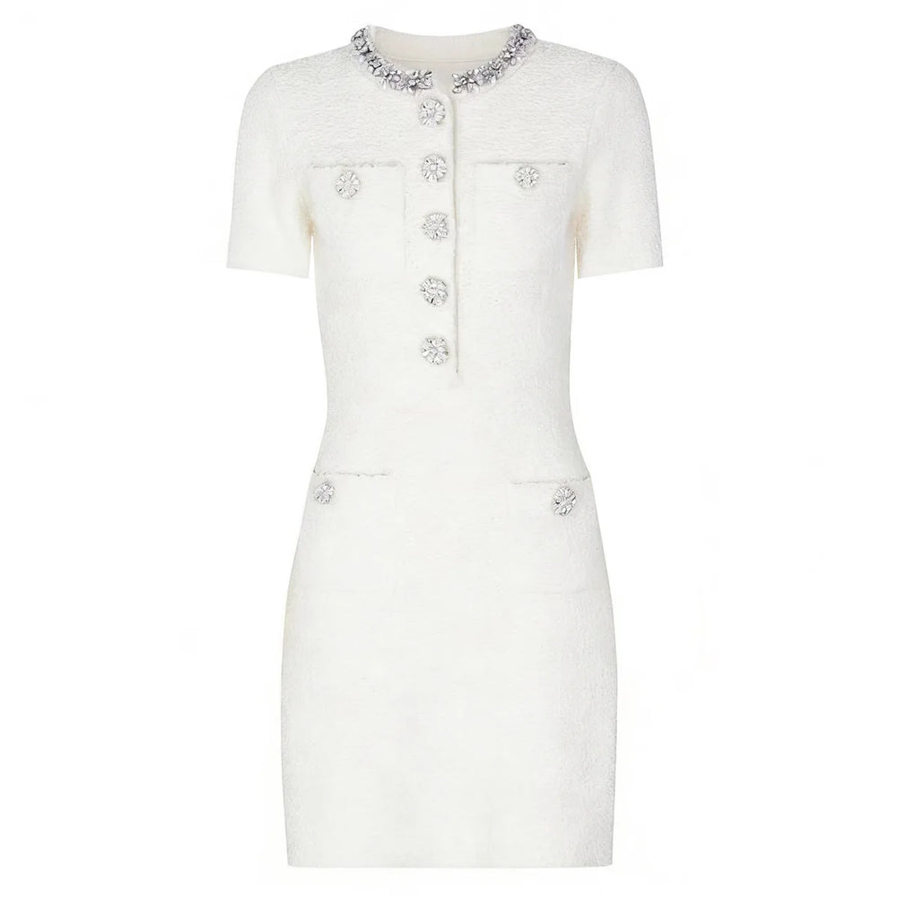 White dress with decorative buttons and embellishments on a white background