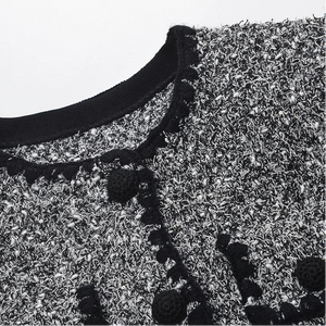Close-up of a textured fabric with floral patterns and a black neckline.