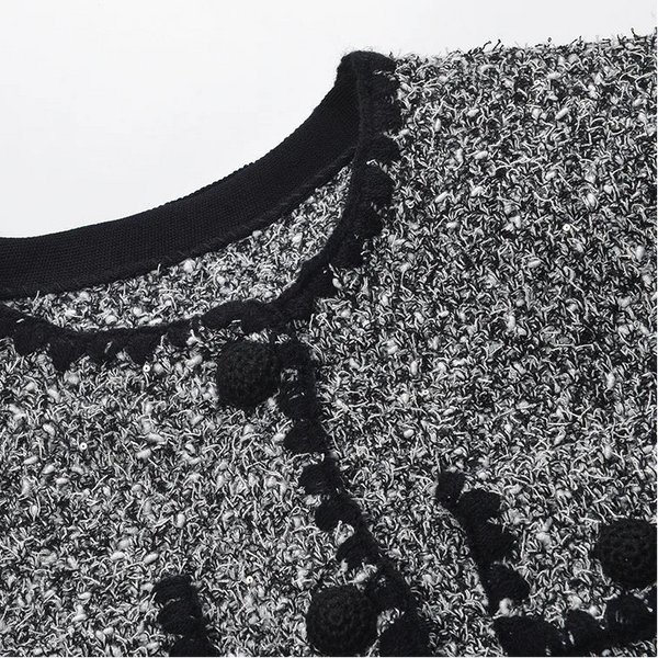 Close-up of a textured fabric with floral patterns and a black neckline.