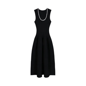 Black dress with a pearl necklace on a white background
