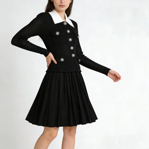 Black dress with white collar and silver buttons on a white background