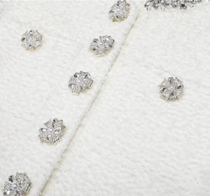 Close-up of diamond earrings on a white textured background
