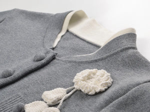 Gray cardigan with white floral details on a light gray background