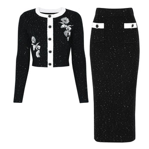 Black embroidered jacket and skirt set on a white background