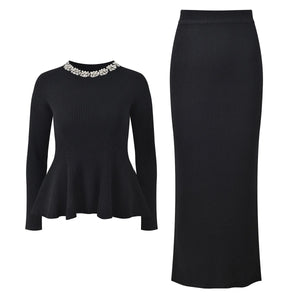 Black long-sleeve top with embellished neckline and black pencil skirt on a white background
