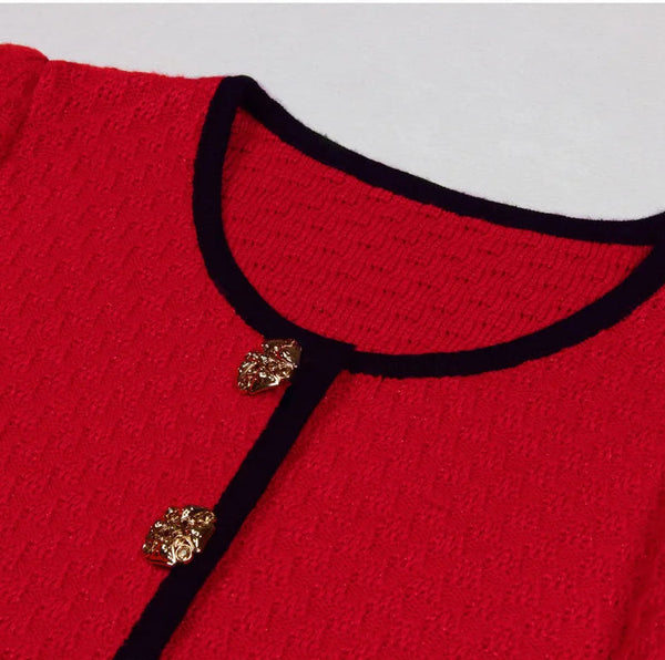 Red garment with black trim and gold buttons on a light gray background