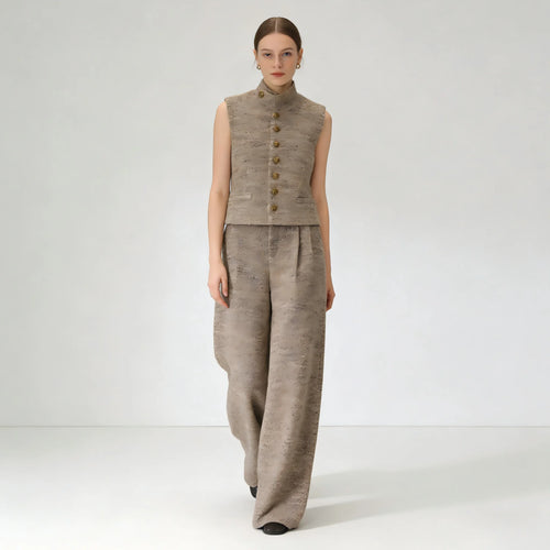 Woman wearing a beige sleeveless top and wide-leg pants on a white background