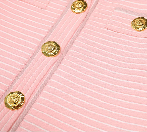 Close-up of a pink textured fabric with gold buttons