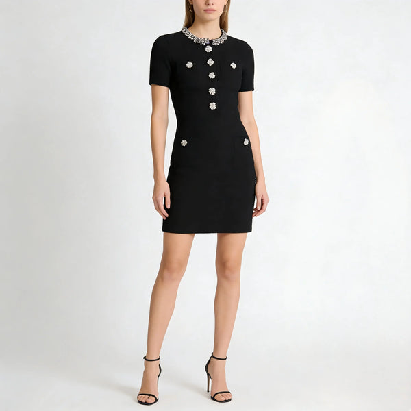 Black dress with white buttons worn by a model on a white background
