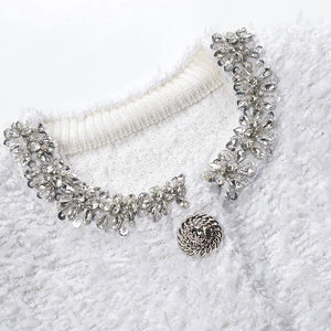 Silver necklace on a white textured surface