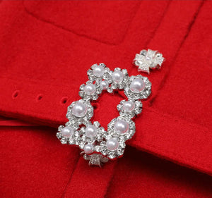 Pearl and crystal brooch on a red fabric background