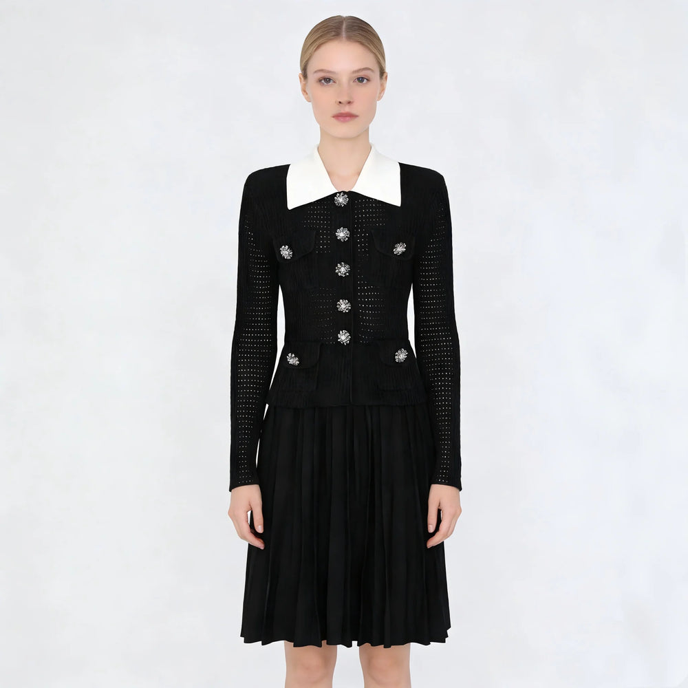 Black dress with white collar and decorative buttons on a white background