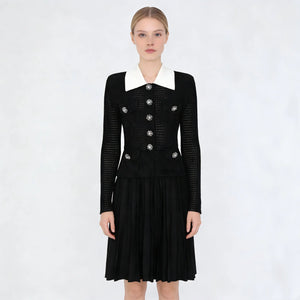 Black dress with white collar and silver buttons on a white background