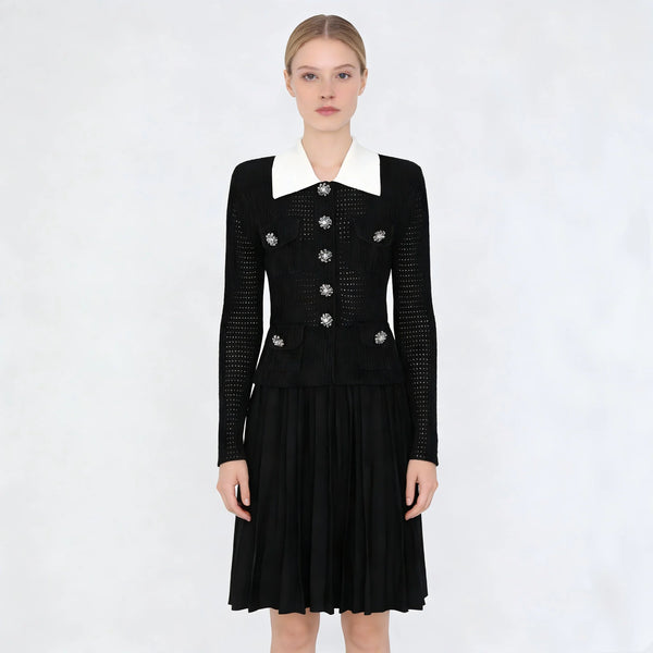 Black dress with white collar and silver buttons on a white background