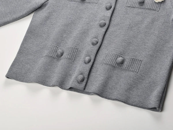 Gray cardigan with button details on a light gray background