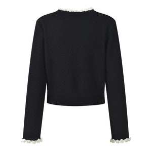 Black textured sweater with white trim on a white background