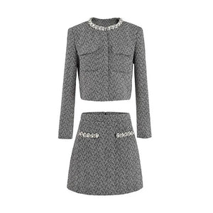 Gray herringbone patterned outfit with embellishments on a white background