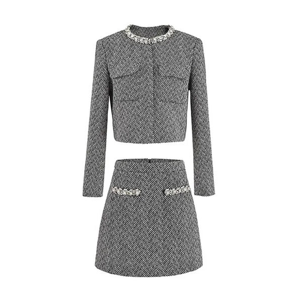Gray herringbone patterned outfit with embellishments on a white background
